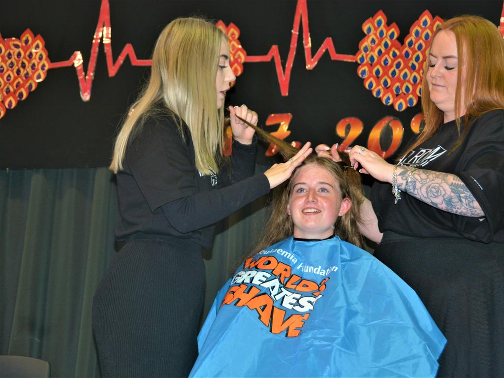 At the St Joseph's College 2023 World's Greatest Shave event is student Jordan Steinhardt getting her hair cut by hairdressers (from left) Abbey McGaw and Rebecca Mortlock. Picture: Rhylea Millar