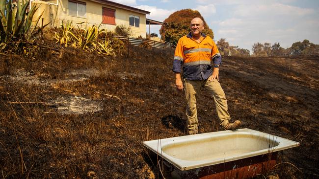 Trevor Larbey surveys his property after nearly losing his house in a bushfire in Flowerdale. Picture: Mark Stewart