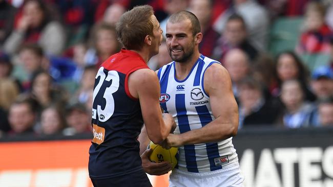 Ben Cunnington of the Kangaroos (right) punches Bernie Vince of the Demons in the stomach. (AAP Image/Julian Smith)