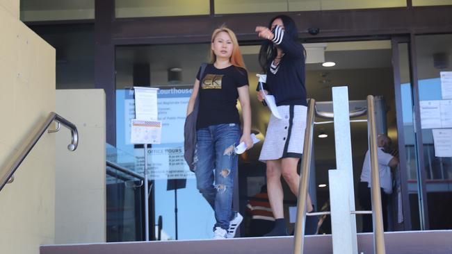 Pu Liu (right) covers her face as she leaves the Mackay courthouse with Ling Yao (left) where both women pleaded guilty to knowingly participating in the provision of prostitution and possessing tainted property.