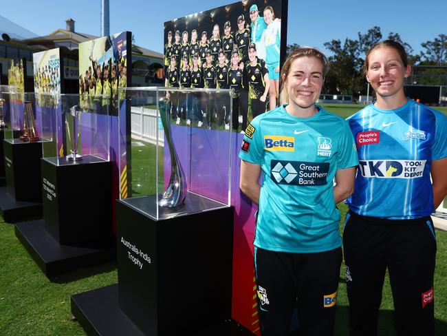 The Heat’s Georgia Redmayne (left) and the Strikers’ Darcie Brown like the look of the silverware won by the national women’s cricket team. Picture: Chris Hyde / Getty Images