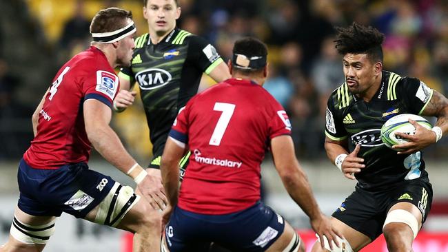 Ardie Savea of the Hurricanes runs at George Smith (right) and Izack Rodda of the Reds on Friday night.