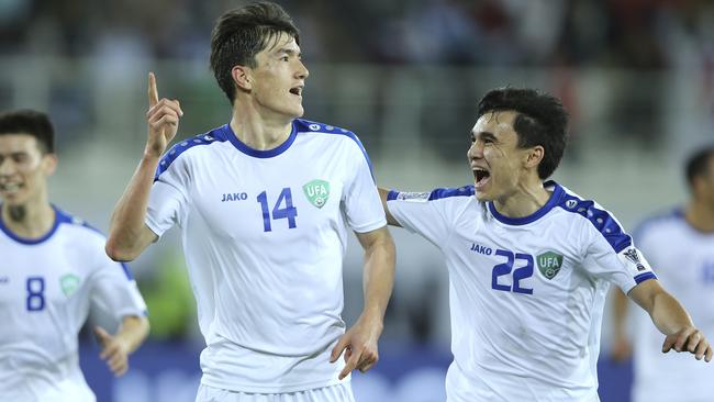 Uzbekistan's Eldor Shomurodov, centre, celebrates after scoring his side's opening goal during the AFC Asian Cup group F soccer match between Japan and Uzbekistan at Khalifa bin Zayed Stadium in Al Ain, United Arab Emirates, Thursday, Jan. 17, 2019. (AP Photo/Kamran Jebreili)