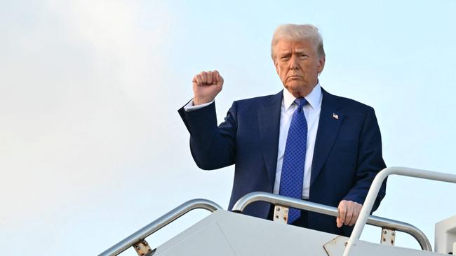 US President Donald Trump pumps his fist as he steps off of Air Force One. Picture: AFP