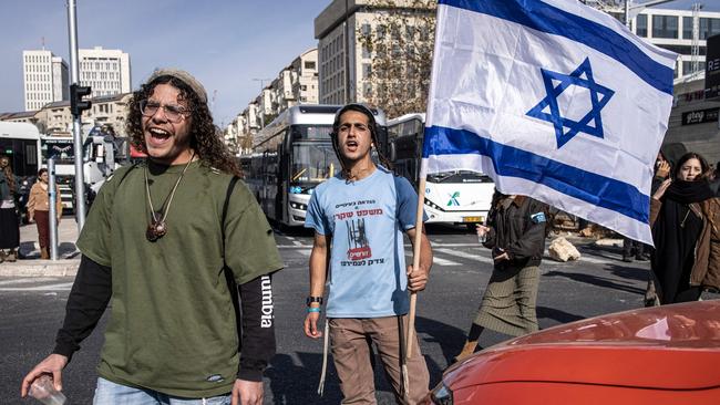 An Israeli demonstrator shout slogans and holds a national flag during a protest against the ceasefire Israel reached the previous day with Hamas, in Jerusalem on January 16,. Picture: John Wessels/AFP