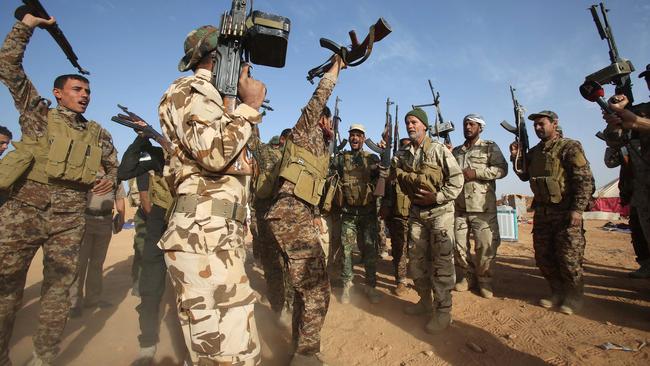 Iraqi fighters from the Shiite Muslim Al-Abbas popular mobilisation unit hold up their weapons in the area surrounding the village of Nukhayb in the embattled Anbar province west of the capital Baghdad, on May 19, 2015. Iraq's army and allied paramilitary forces massed around Ramadi, looking for swift action to recapture the city from the Islamic State (IS) group before it builds up defences. AFP PHOTO / MOHAMMED SAWAF