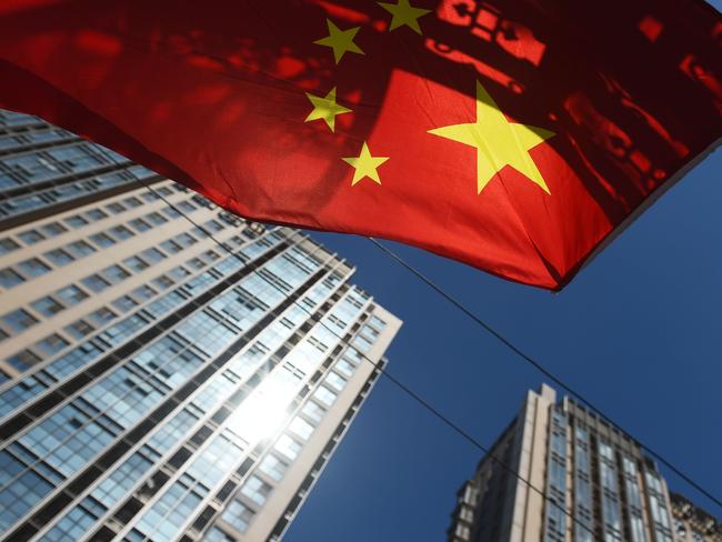 (FILE) This file photo taken on September 11, 2015 shows a Chinese flag flying near apartment buildings in Beijing.  Chinese household debt has risen at an "alarming" pace as property values have soared, analysts say, raising the risk that a real estate downturn could send shockwaves through the world's second largest economy. / AFP PHOTO / GREG BAKER