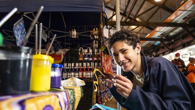 Benji Wenitong paints a boomerang at Toowoomba NAIDOC Week celebrations at The Goods Shed, Monday, July 4, 2022. Picture: Kevin Farmer