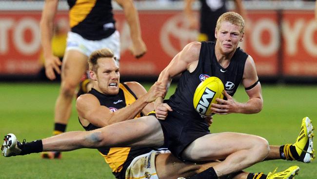 Luke McGuane of Richmond (left) tackles Joshua Bootsma of Carlton in the dying minutes of the match in the round one AFL match between Carlton and Richmond in Melbourne, Thursday, March 28, 2013. Richmond defeated Carlton 14.22 (106) to 14.17 (101). (AAP Image/Joe Castro)