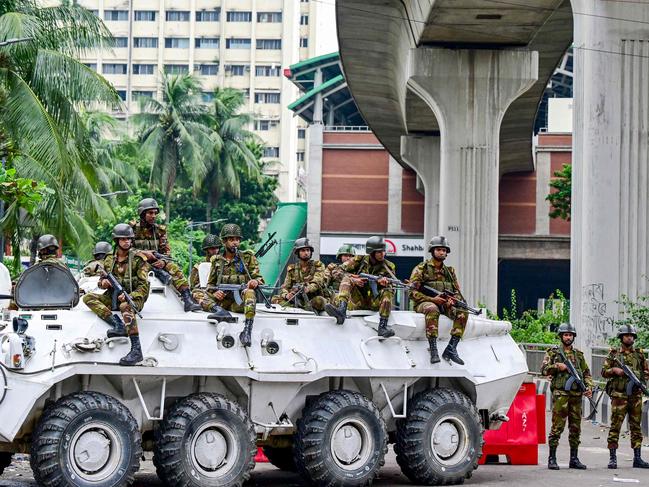 Bangladesh army personnel stand guard during a curfew following clashes between police and Anti-Discrimination Student Movement activists amid anti-government protests in ShahbagÂ area of Dhaka on August 5, 2024. Bangladeshi security forces patrolled the capital on August 5, as protesters demanding Prime Minister Sheikh Hasina's resignation said they would take to Dhaka's streets again following the deadliest day of unrest since demonstrations erupted last month. (Photo by Munir UZ ZAMAN / AFP)