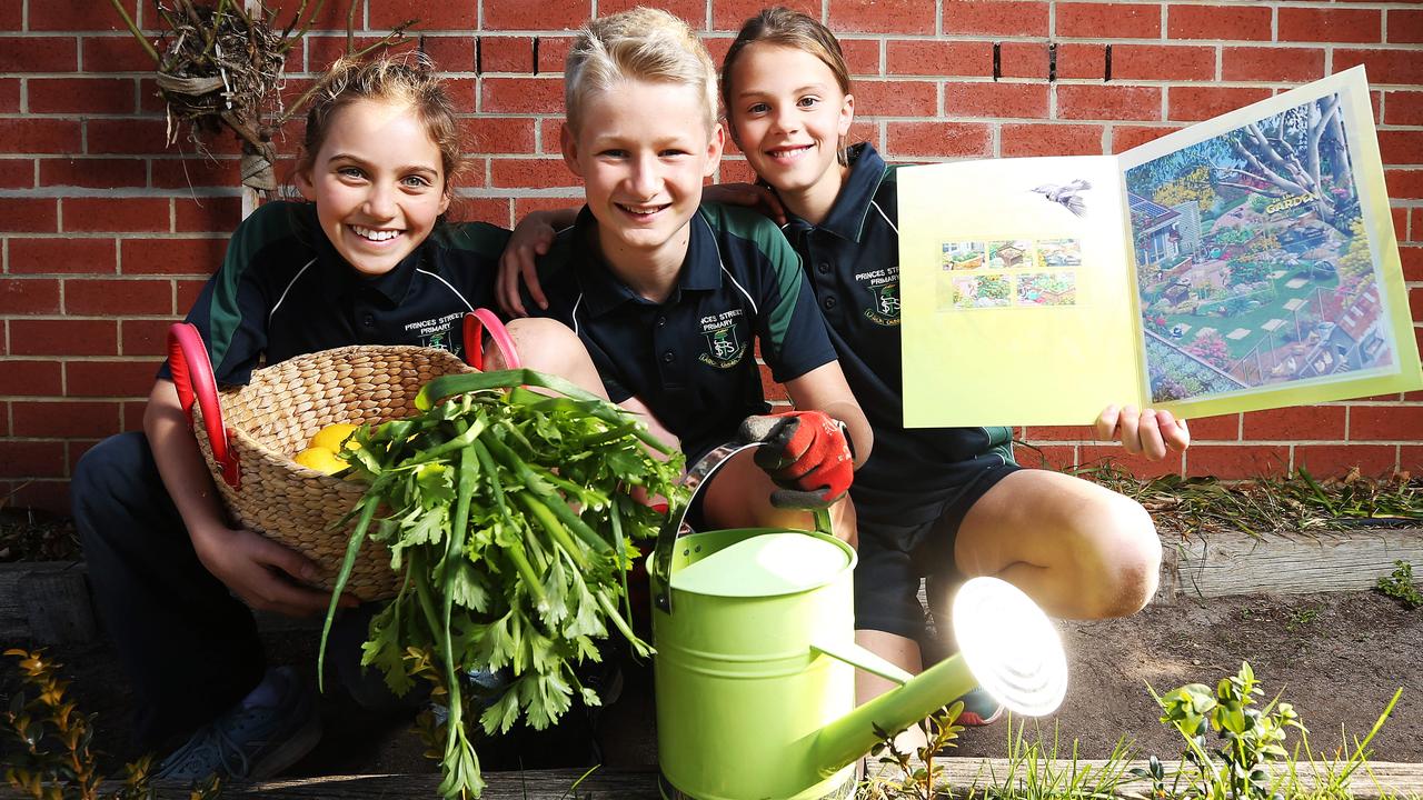 Zara, Tom and Didi from Princes Street Primary School, Tasmania, in their school garden with a set of In the Garden stamps. Picture: Zak Simmonds