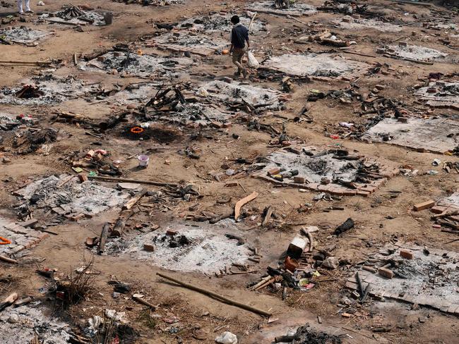 A relative collects the remains of a COVID-19 victim after a mass cremation at a cremation ground in New Delhi. Picture: AFP