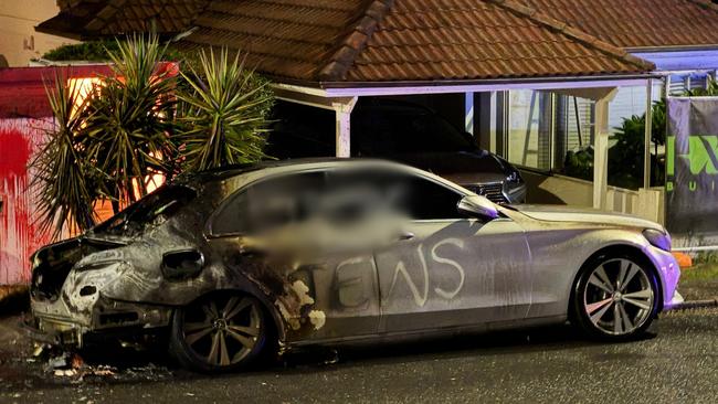 A car is shown torched and vandalised with anti-Semitic graffiti on Friday on Military Rd, Dover Heights, in Sydney’s east.