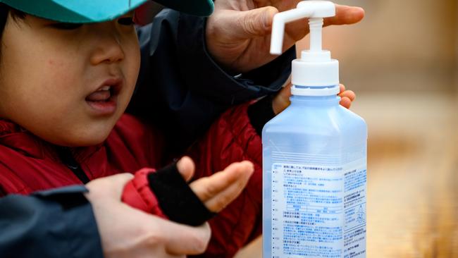 People clean their hands with hand sanitiser in Japan. Picture: AFP