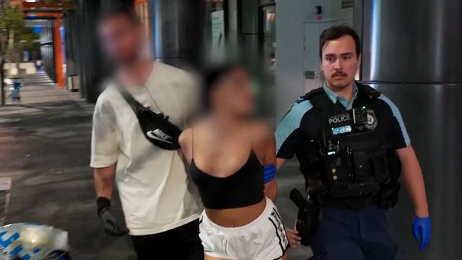 A woman arrested while white bags were taken into evidence. Picture: NSW Police