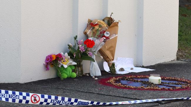 Tributes have been laid at a Thorneside unit complex, where a ferocious townhouse fire claimed the life of eight-year-old Raven Contini, while her babysitter remains missing. Picture: NewsWire/Tertius Pickard