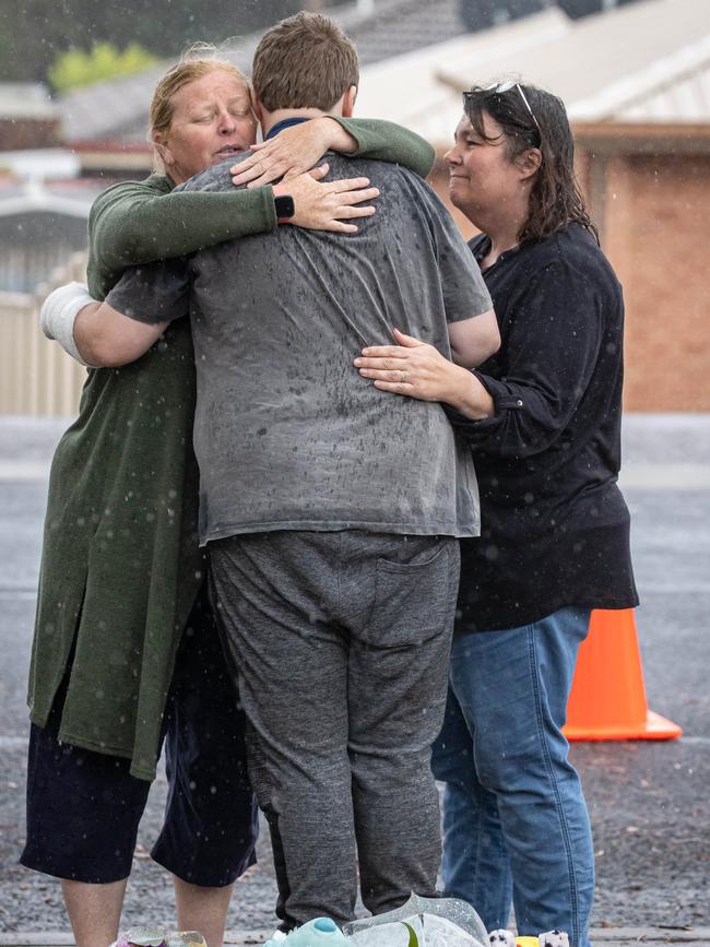 Beau is comforted at the memorial. Picture: Jason Edwards