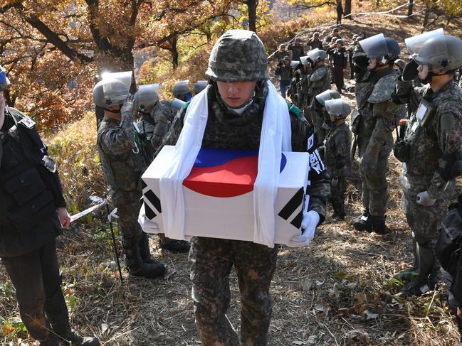 TOPSHOT - A South Korean soldier (C) carries a coffin containing a piece of bone believed to be the remains of an unidentified South Korean soldier killed in the Korean War in the Demilitarized Zone (DMZ) dividing the two Koreas in Cheorwon, 90 kilometers northeast of Seoul, on October 25, 2018. - The excavation project is part of a comprehensive military agreement that the two Koreas' defence ministers signed last month after the third summit between South Korean President Moon Jae-in and North Korean leader Kim Jong Un in Pyongyang. (Photo by Jung Yeon-je / pool / AFP)