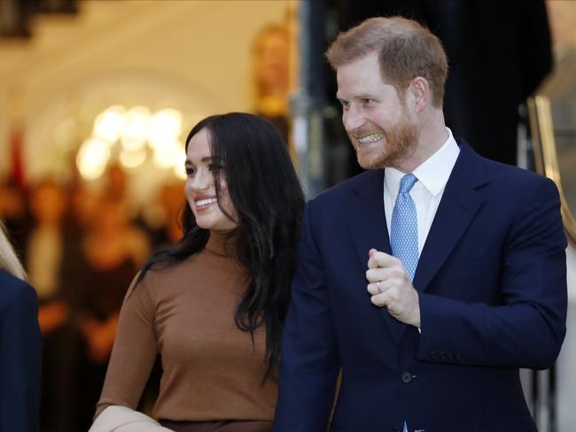 An excited Prince Harry leaves Canada House in London with Meghan Markle. Picture: AP