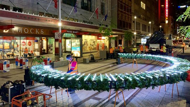 Nocturnal work goes on for the giant Christmas decorations.