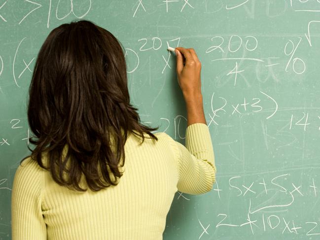 Female student writing on blackboard