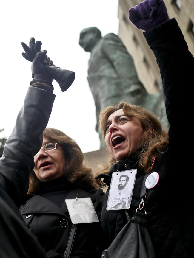 Faces of the missing ... Human Rights activists march in Santiago on the 44th anniversary of the coup. Picture: AFP