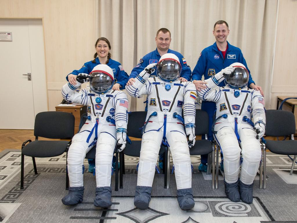 jsc2019e009960 - At the Baikonur Cosmodrome in Kazakhstan Expedition 59 crewmembers Christina Koch of NASA (left), Alexey Ovchinin of Roscosmos (center) and Nick Hague of NASA (right) share a playful moment with their Sokol launch and entry suits Feb. 27