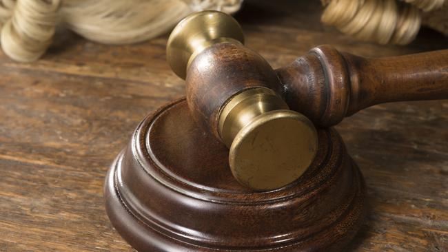 Wooden block, judge's wig and gavel on a wooden desk