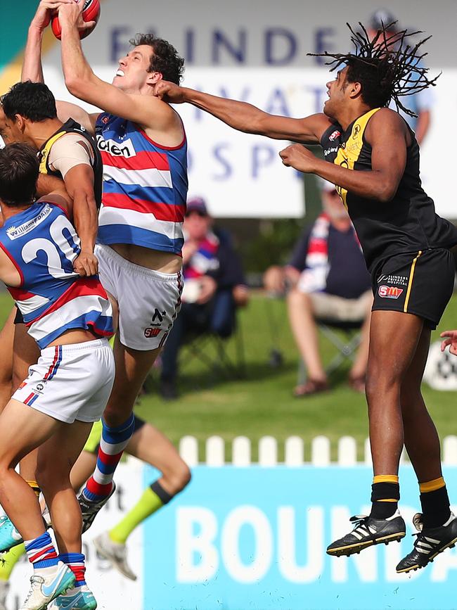 Neil Vea Vea – playing for Glenelg – attempts to punch the ball from the hands of Central’s Darcy Fort. Picture: Tait Schmaal