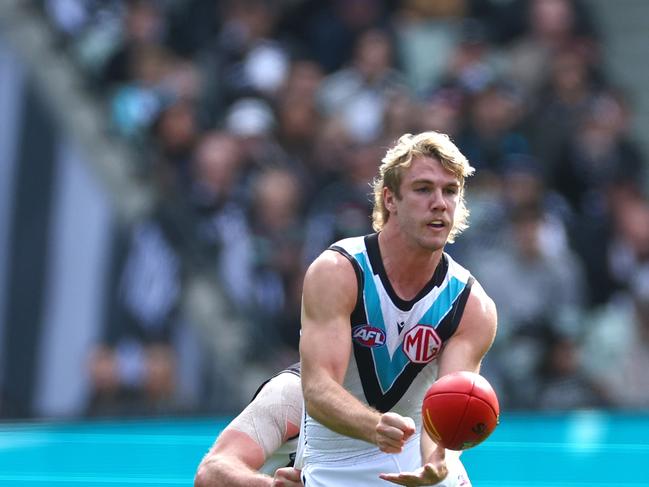 MELBOURNE, AUSTRALIA – APRIL 20: Jason Horne-Francis of the Power handballs while being tackled during the round six AFL match between Collingwood Magpies and Port Adelaide Power at Melbourne Cricket Ground, on April 20, 2024, in Melbourne, Australia. (Photo by Quinn Rooney/Getty Images)