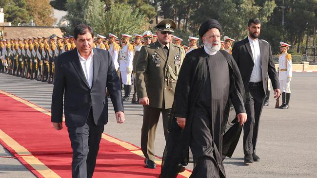 Iran's President Ebrahim Raisi being escorted by government officials to board his aircraft to depart from Tehran's Mehrabad International Airport ahead of his trip to Saudi Arabia. Picture: AFP