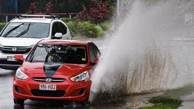 A car drives through flash flooding. Picture Lachie Millard