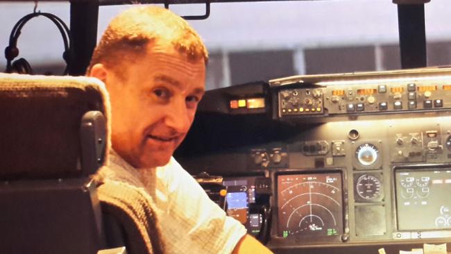 Mick Gilbert in a Boeing 777 simulator. The aviation enthusiast has compiled a meticulous theory of what may have happened to MH370. Picture: Supplied