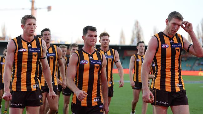 Hawthorn players walk off after losing to North Melbourne.