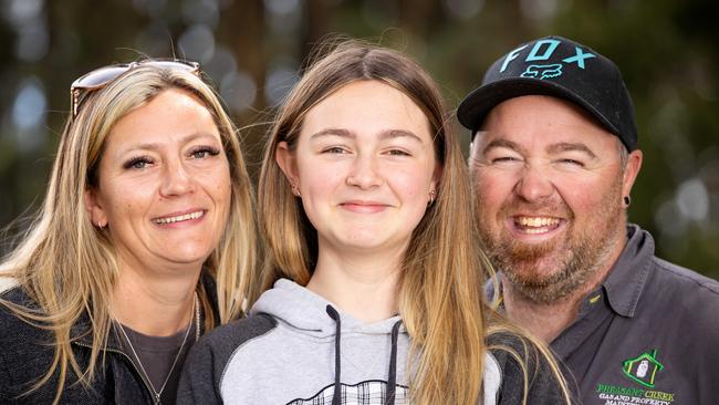 Tahnee Taylor-Pike, 12 – pictured with mum Kelly Pike and dad Dan Taylor – came to the rescue when Mr Taylor suffered two major cuts on his leg while grinding in the garage. Picture: Mark Stewart