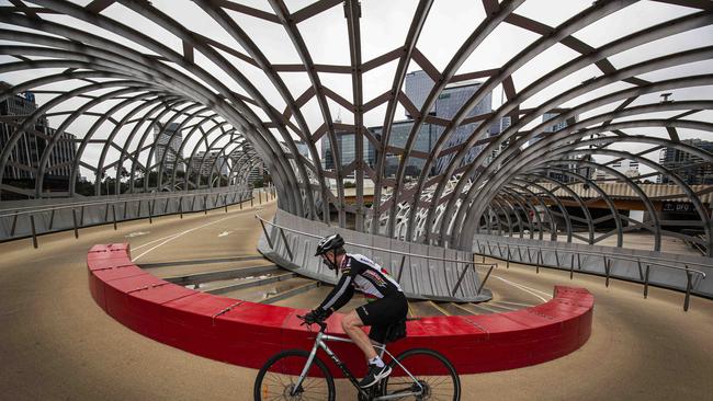 A cyclist rides his bike at a deserted South Wharf in Melbourne. Picture: NCA NewsWire/Daniel Pockett