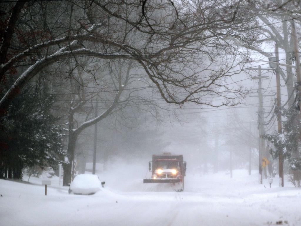 A plough drives down Lower Sheep Pasture road shovelling snow in Stony Brook, New York.