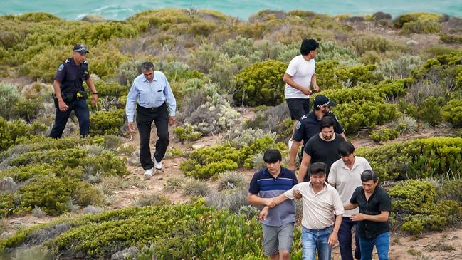 Police escort relatives back from the rocky outcrop. Picture: AAP / Mike Burton