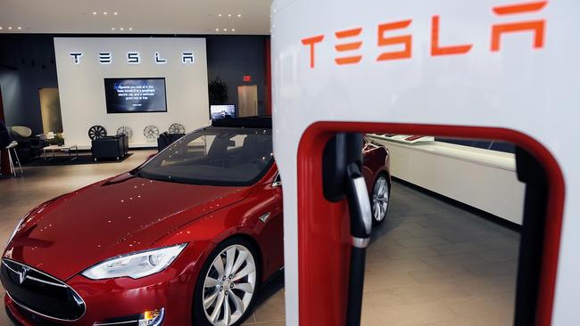 A Model S P85D electric vehicle (EV) sits next to a charging station displayed at the Tesla Motors Inc. retail store in San Jose, California, U.S., on Thursday, Aug. 20, 2015. Tesla Motors Inc. has launched a wholesale revamp of its stores worldwide as the electric-car company prepares to debut the Model X, its first sport-utility vehicle. Photographer: Michael Short/Bloomberg