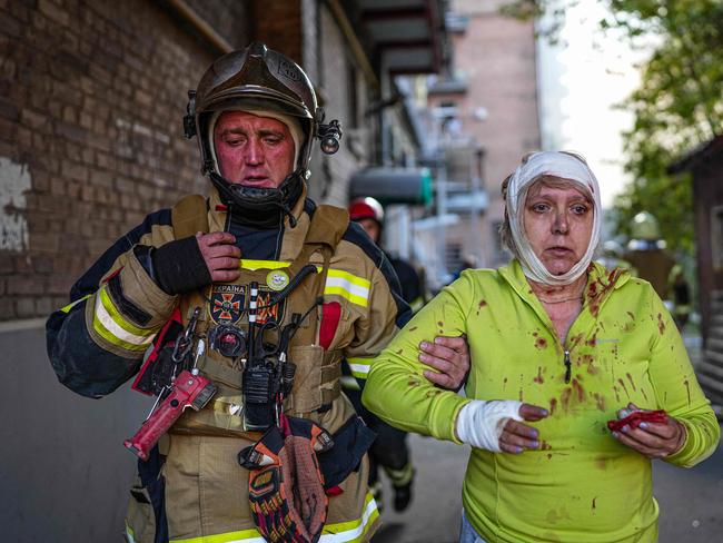 A rescuer helping an injured woman after several strikes hit the Ukrainian capital of Kyiv, amid Russia's invasion of Ukraine. Picture: State Emergency Service of Ukraine / AFP