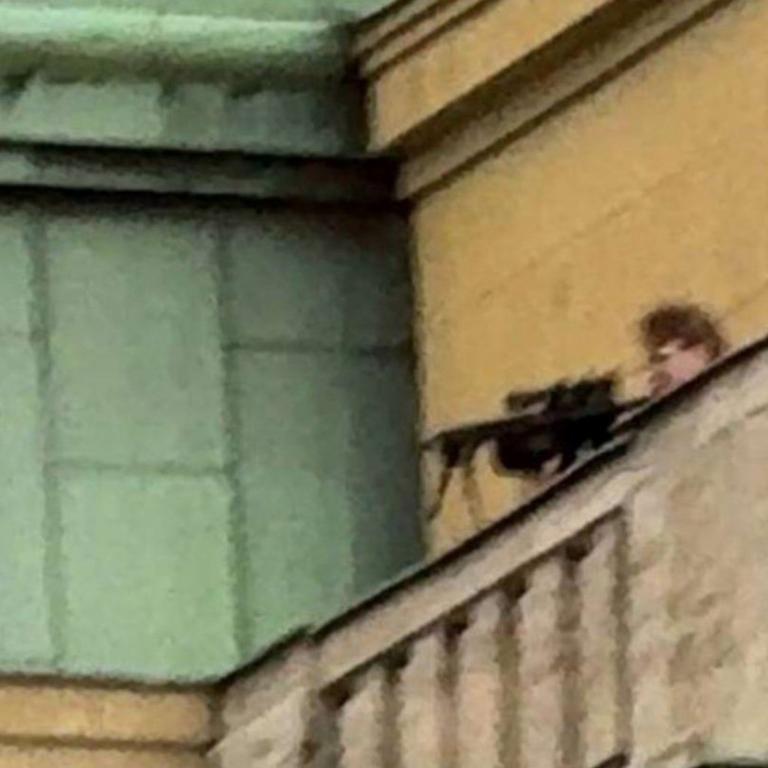 Kozak pictured on the roof of the university building holding a rifle. Picture: X