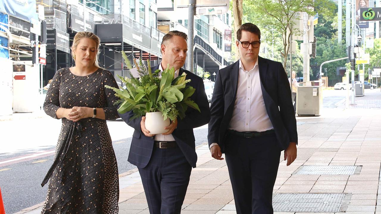 Lord Mayor Adrian Schrinner with his wife Nina and councillor Ryan Murphy prepare to leave a tribute at the scene of the crash. Picture: David Clark