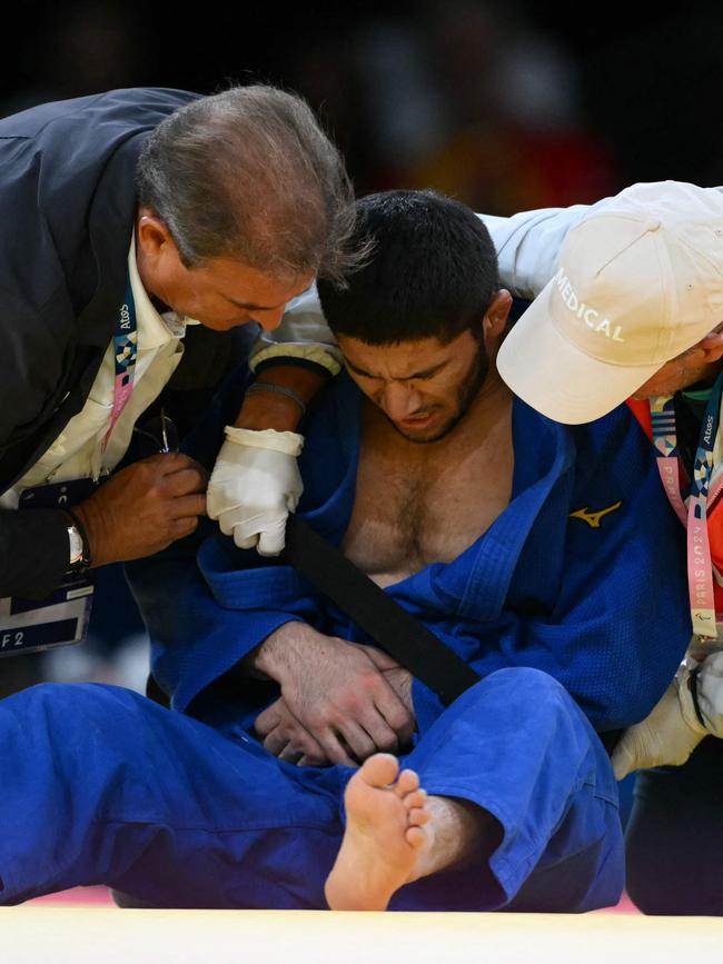 Emomali receiving medical treatment after the injury. (Photo by Luis ROBAYO / AFP)