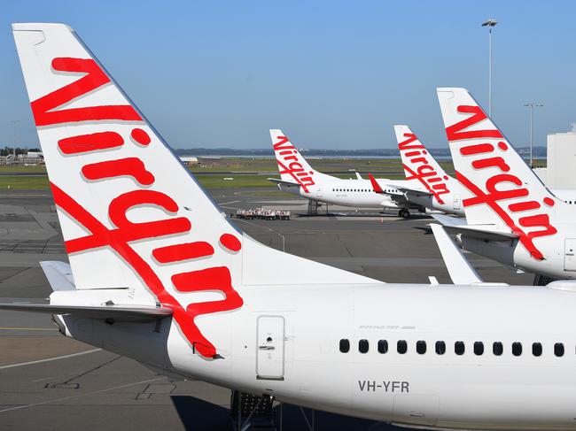 A general view of Virgin Australia aircraft parked at Sydney Domestic Airport, in Sydney, Tuesday, April 21, 2020. Virgin confirmed it had gone into administration on Tuesday, threatening up to 10,000 airline jobs after a board meeting of its international shareholders voted on Monday against providing additional financial support. (AAP Image/Dan Himbrechts) NO ARCHIVING