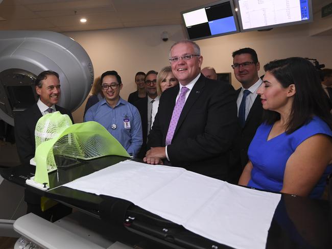 Prime Minister Scott Morrison (centre) inspects a radiation machine during a visit to Icon Cancer Centre in Canberra with Health Minister Greg Hunt (left) yesterday. Picture: Lukas Coch/AAP