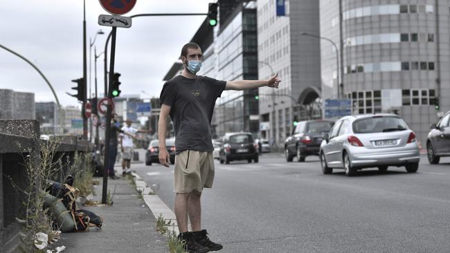 A man wearing a protective face mask, hitchhikes on a road in Paris. Authorities in Paris are expected to announce that people will have to wear face masks along the banks of the Seine and around Canal Saint-Martin, as well as tourist destinations. Picture: Stephane de Sakutin/AFP