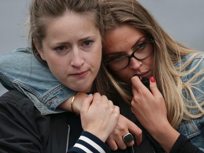 Two women react as they pause at the mound of flowers outside City Hall in London in tribute to the victims of the terror attack on London Bridge and at Borough Market. Picture: AFP/Daniel Leal-Olivas