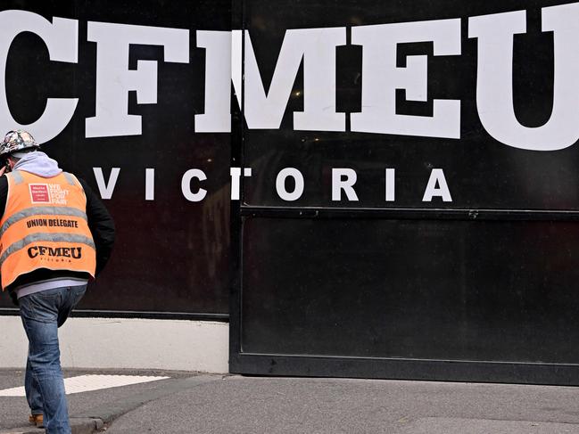 A union official walks past the Victorian headquarters of the Construction, Forestry and Maritime Employees Union (CFMEU) in Melbourne on July 17, 2024. Australia on July 17 pledged to clean up one of its most powerful trade unions, which has been tarred by accusations of intimidating "thuggery", corruption and cosy ties to organised crime. (Photo by William WEST / AFP)