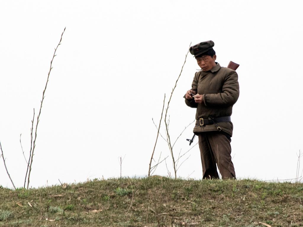 A North Korean soldier rolls a cigarette near the Yalu river near Sinuiju. Picture: Johannes Eisele/AFP