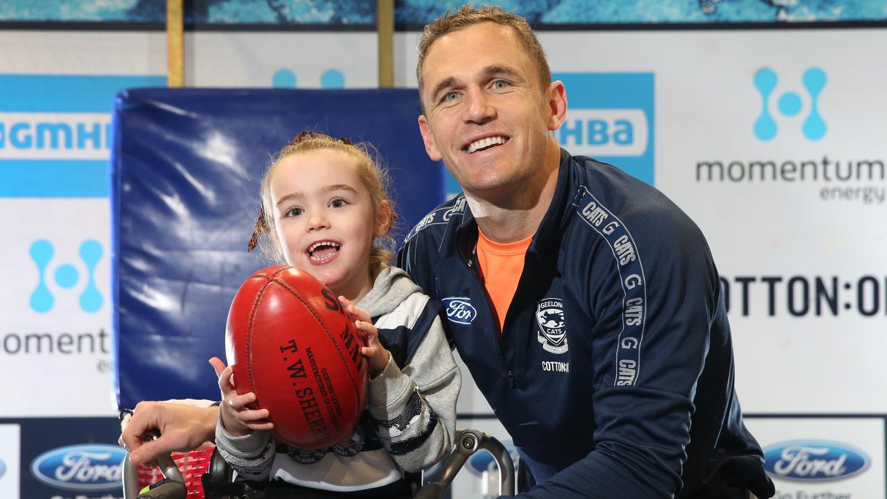 Joel Selwood with five-year-old Keisha Low who lives with Cerebral Palsy. Low, a big Selwood fan, ran through the Cats banner before a game in 2017. Picture: Peter Ristevski